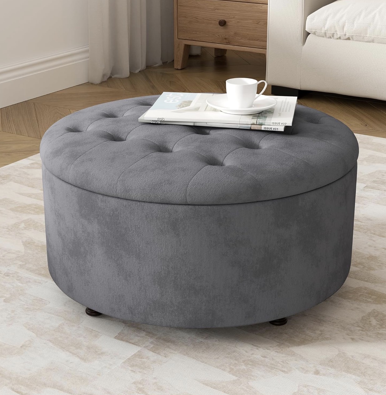 Round grey tufted storage ottoman.